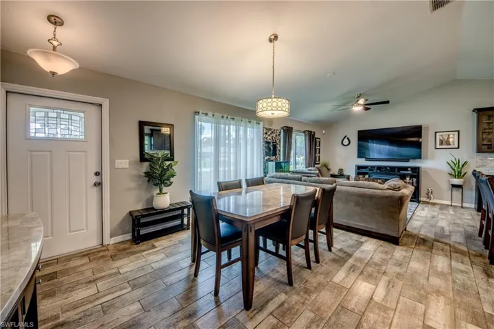Dining space featuring a wealth of natural light, vaulted ceiling, ceiling fan, and light hardwood / wood-style floors