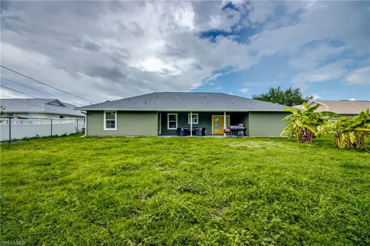 Back of property featuring a lawn