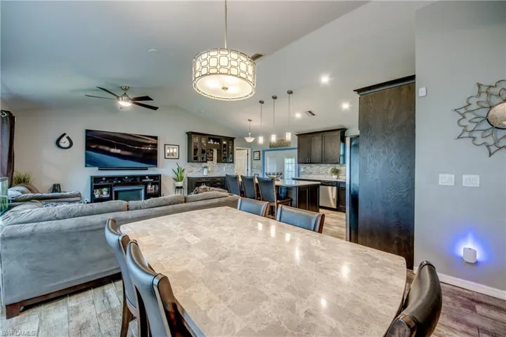 Dining space with ceiling fan, lofted ceiling, and wood-type flooring