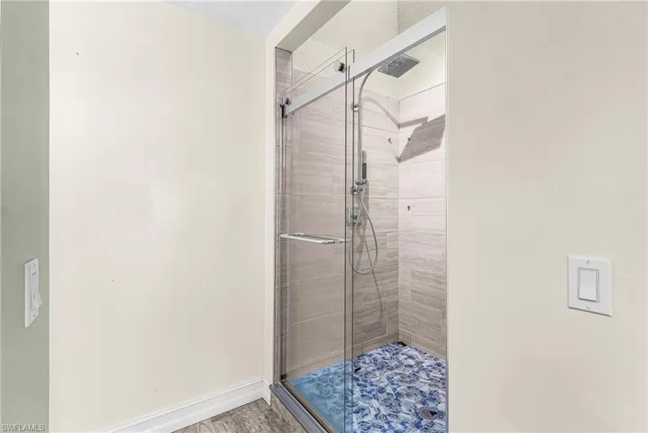 Bathroom featuring baseboards and a shower stall