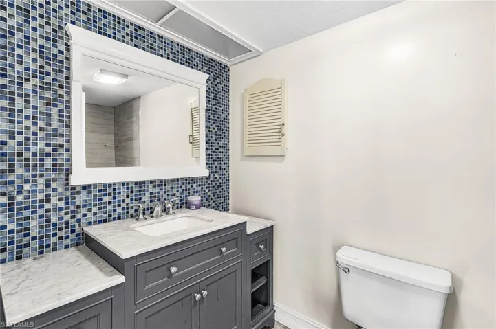 Bathroom featuring tasteful backsplash, vanity, and a textured ceiling