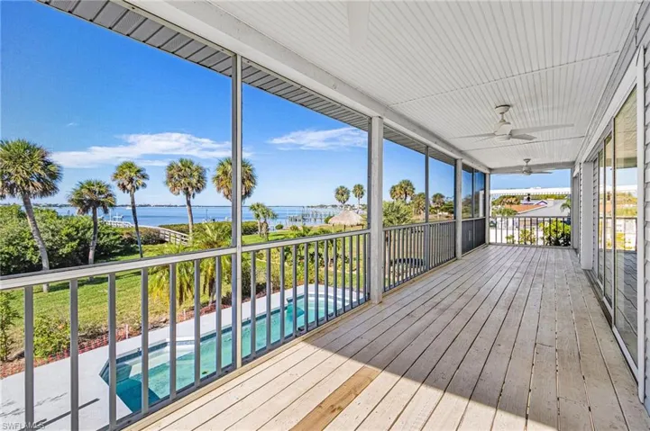 Deck with an outdoor pool, a ceiling fan, and a sunroom
