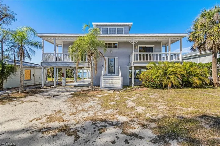View of front of property featuring a carport, a porch, and driveway