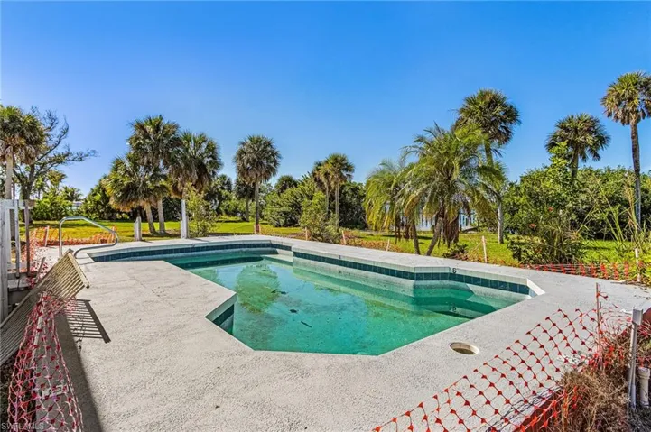 Swimming pool with a patio area and a yard