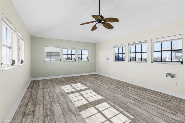 Unfurnished room with vaulted ceiling, a ceiling fan, and light wood-style flooring