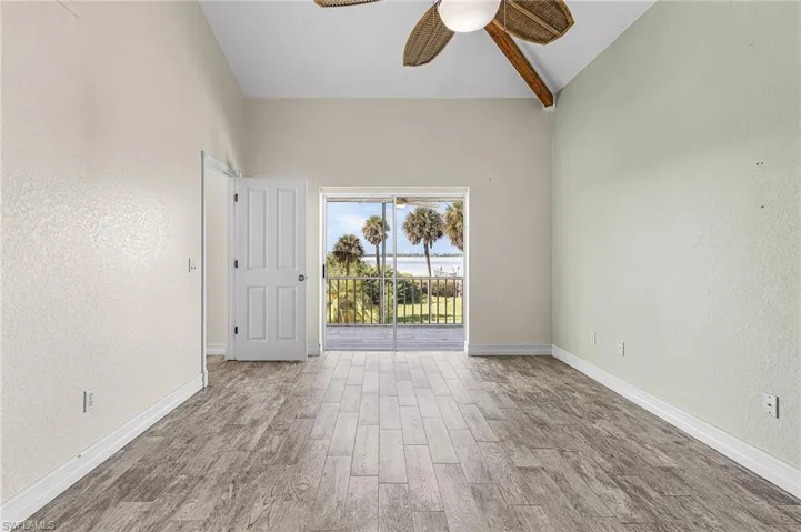 Unfurnished room featuring lofted ceiling, wood tiled floors, a textured wall, and a ceiling fan