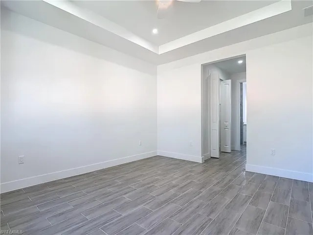 Empty room featuring wood finish floors, recessed lighting, visible vents, a ceiling fan, and baseboards