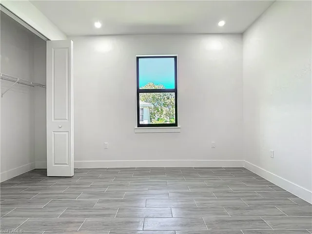 Unfurnished bedroom with recessed lighting and baseboards