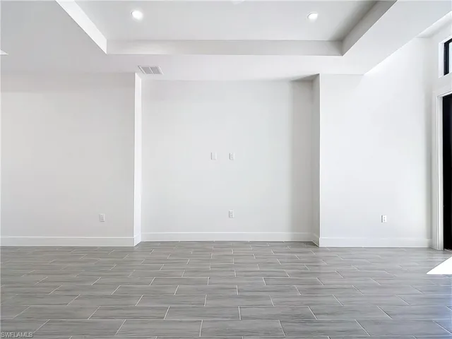 Empty room with wood tiled floor, visible vents, baseboards, and recessed lighting