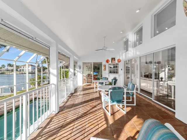 Sunroom / solarium with lofted ceiling, ceiling fan, and a water view