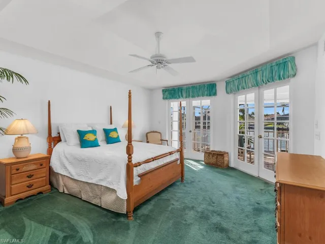 Carpeted bedroom with access to exterior, french doors, and ceiling fan