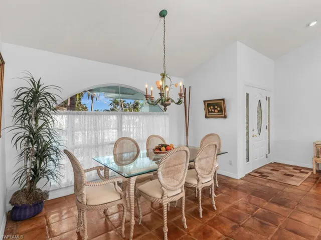 Dining space featuring vaulted ceiling and a notable chandelier
