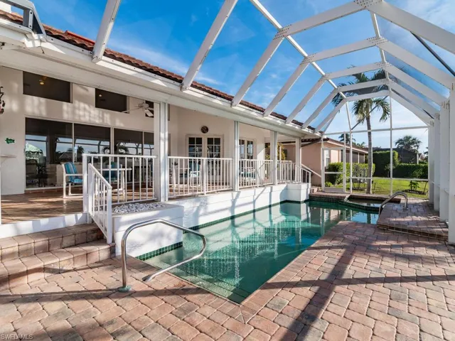 View of swimming pool featuring a lanai, ceiling fan, and a patio area