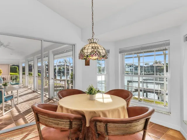 Dining area with vaulted ceiling, a water view, and ceiling fan