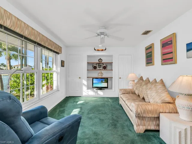 Carpeted living room with ceiling fan