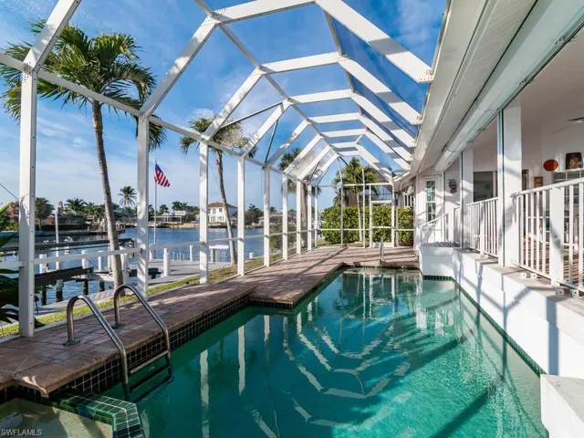 View of swimming pool with a lanai, a patio area, and a water view