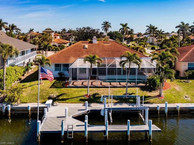 View of dock with a yard, a lanai, and a water view