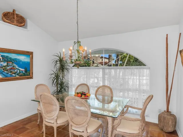 Dining area with a notable chandelier and vaulted ceiling