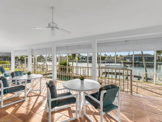 Sunroom with ceiling fan and a water view