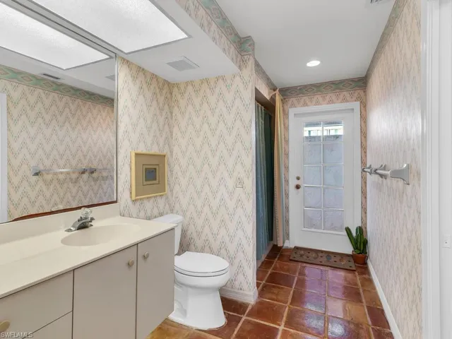 Bathroom featuring vanity, toilet, a skylight, and tile patterned flooring