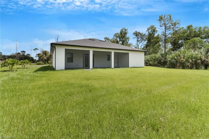Rear view of house featuring a yard