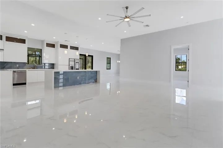 Kitchen featuring white cabinetry, ceiling fan, stainless steel appliances, and plenty of natural light