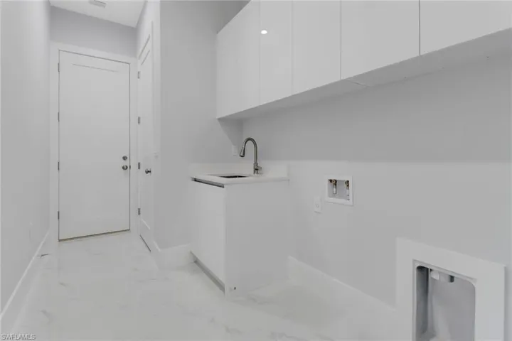 Washroom with sink, washer hookup, and cabinets