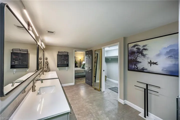 Modern primary bathroom showcasing a dual-sink vanity with white countertops and brushed nickel finishes.
