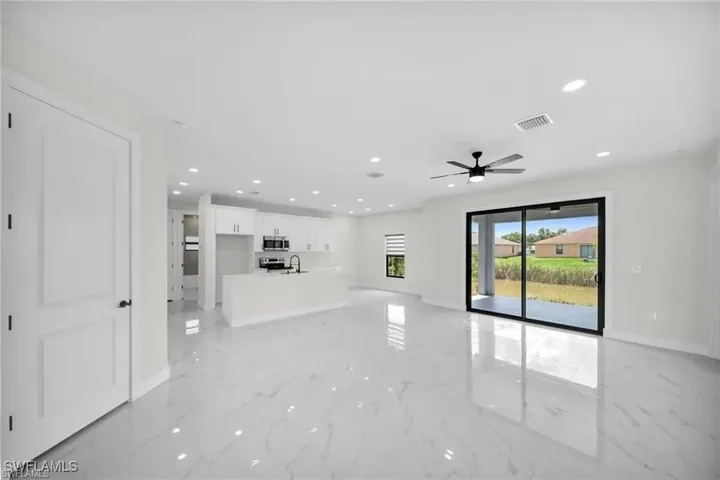 Unfurnished living room featuring recessed lighting, light marble finish floors, and ceiling fan