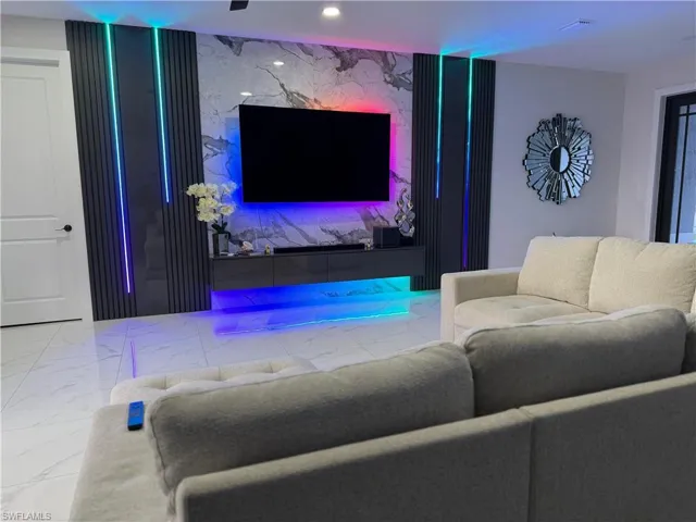 Living area featuring an accent wall and marble finish floors