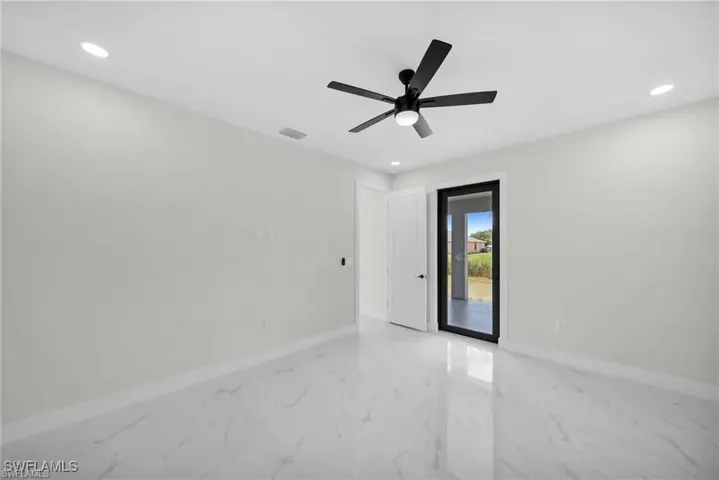 Empty room featuring light marble finish flooring, recessed lighting, and a ceiling fan