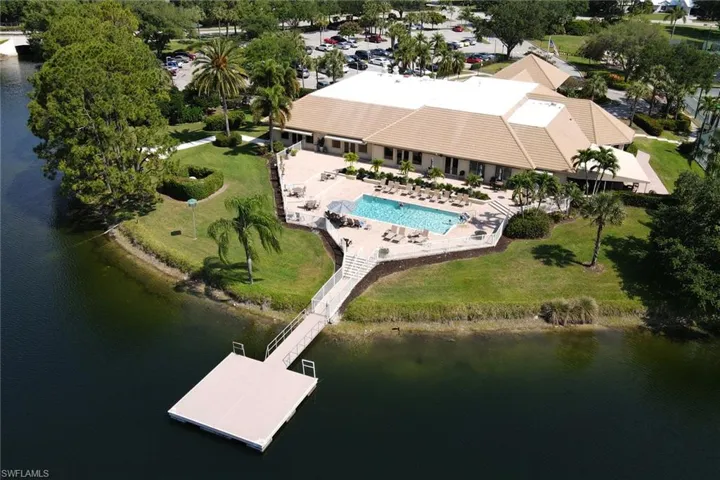 Drone / aerial view of a nearby body of water and a pool