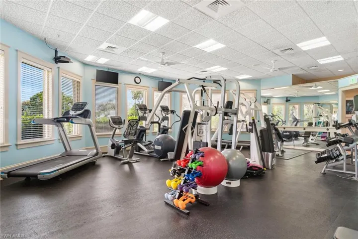 Exercise room with a ceiling fan and a drop ceiling