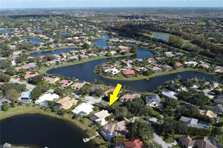 Aerial view of property's location featuring a nearby body of water and nearby suburban area