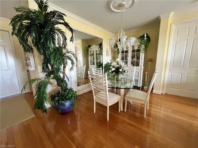 Dining Room featuring a chandelier, crown  moldings, and light wood finished floors