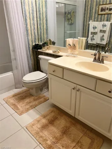 Full bath featuring tub/shower, title floors, and vanity,