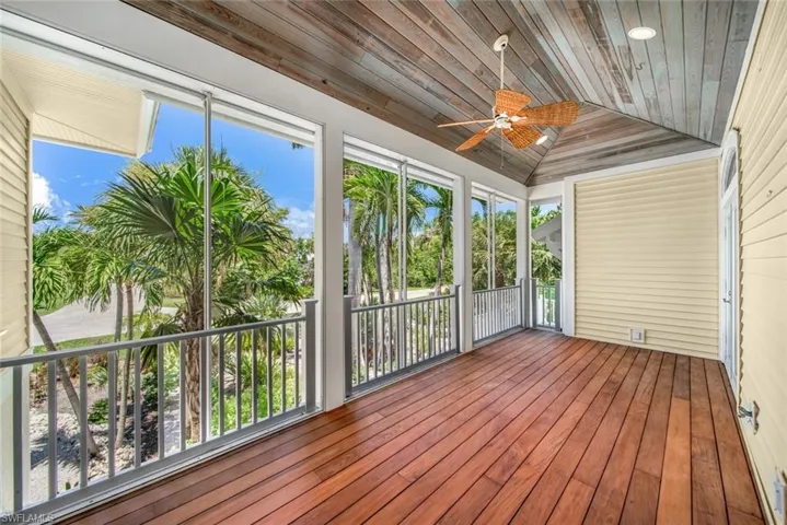 Unfurnished sunroom with wooden ceiling, ceiling fan, vaulted ceiling, and a healthy amount of sunlight