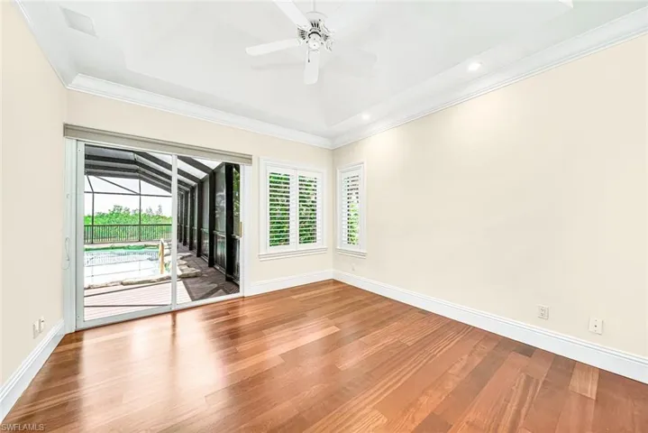 Unfurnished room with a tray ceiling, wood-type flooring, and a wealth of natural light