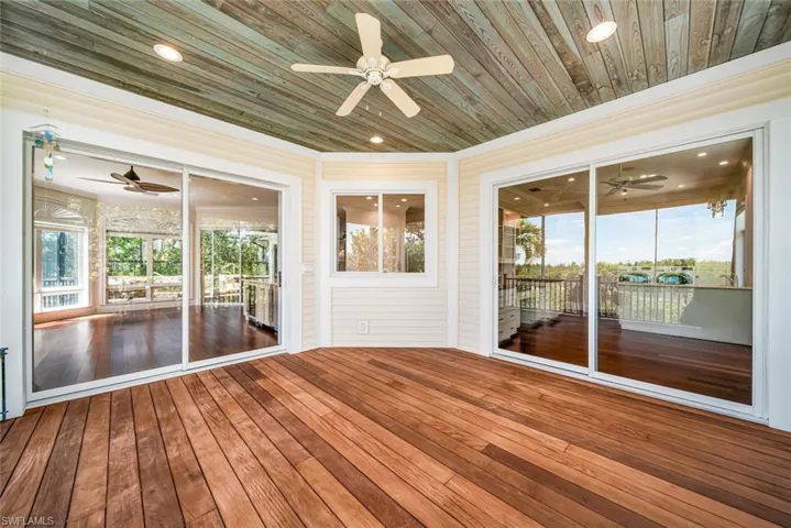 Unfurnished sunroom featuring wooden ceiling and ceiling fan