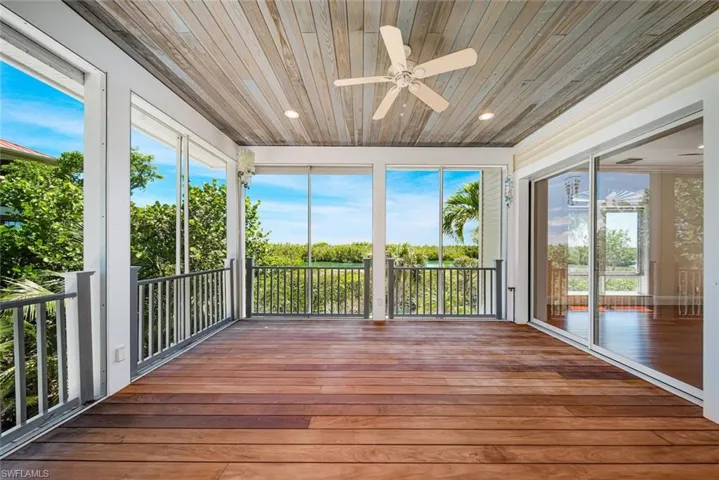 Unfurnished sunroom with ceiling fan and wood ceiling