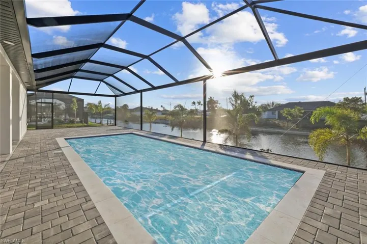 View of pool featuring a lanai, a patio area, and a water view