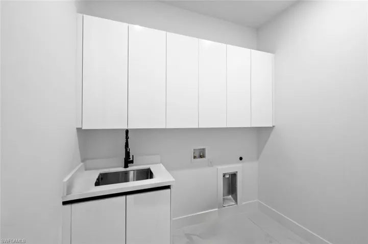 Washroom featuring electric dryer hookup, cabinets, sink, and hookup for a washing machine