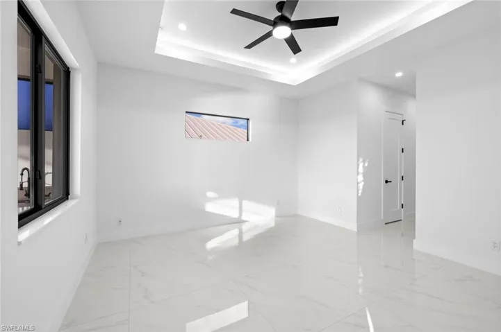 Empty room with a raised ceiling and ceiling fan
