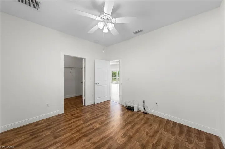 Recessed lighting, wood-finish flooring, ceiling fan, and white doors