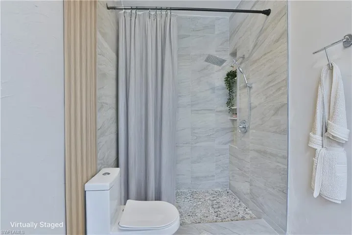 Bathroom with tiled shower and toilet