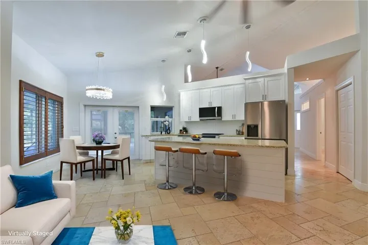 Kitchen with a kitchen bar, visible vents, a kitchen island, stainless steel appliances, and backsplash