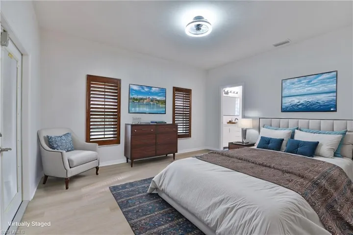 Bedroom featuring light wood finished floors, visible vents, and baseboards