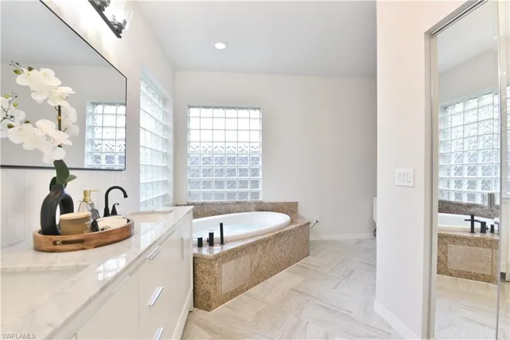 Full bath with a bath, a sink, and double vanity