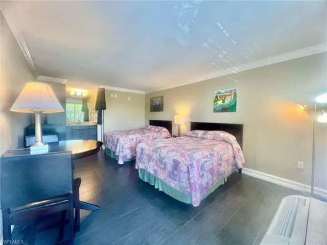 Bedroom with crown molding and dark hardwood / wood-style flooring