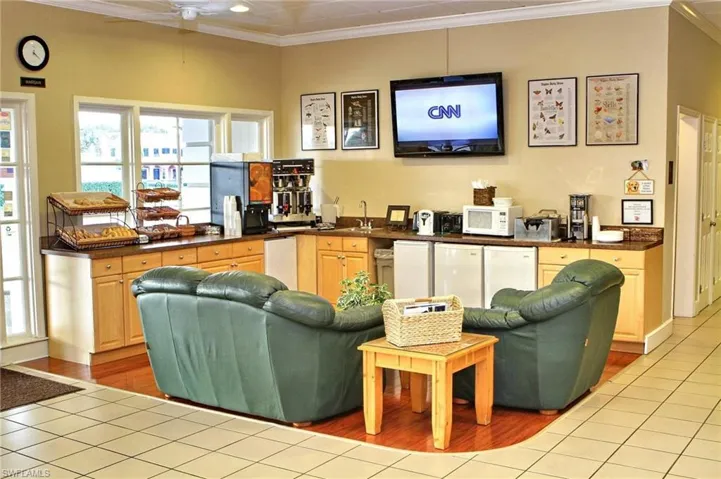 Living room with crown molding, light tile patterned floors, and ceiling fan